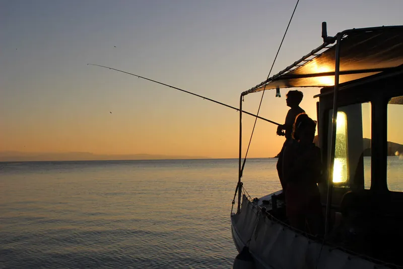 Pêche depuis le pont au coucher du soleil