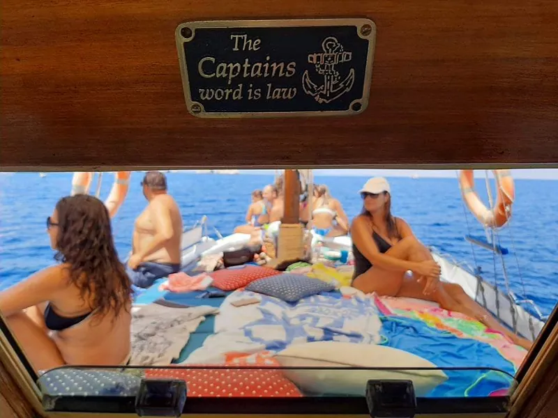 Guests on the foredeck, under the sign “The Captain’s word is law”