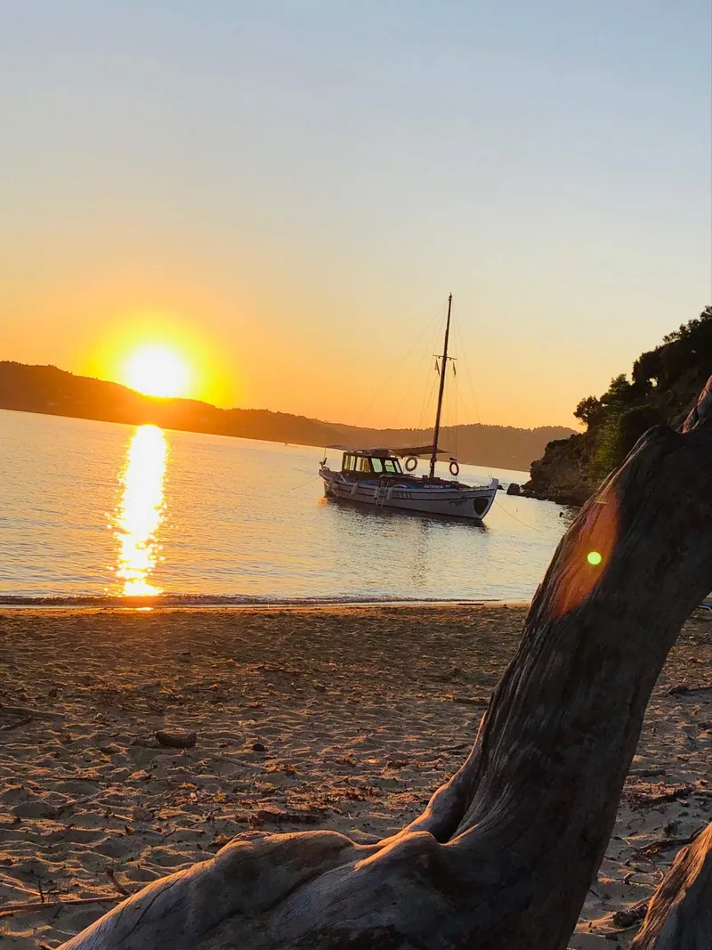 Η Αρτέμιδα αγκυροβολημένη στο ηλιοβασίλεμα, από την παραλία