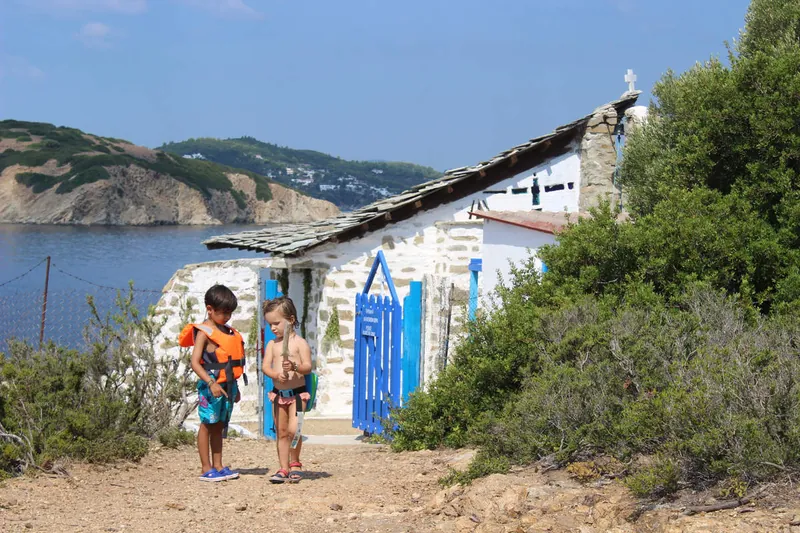 Επιβάτες σε ένα μικρό λευκό ξωκλήσι δίπλα στη θάλασσα
